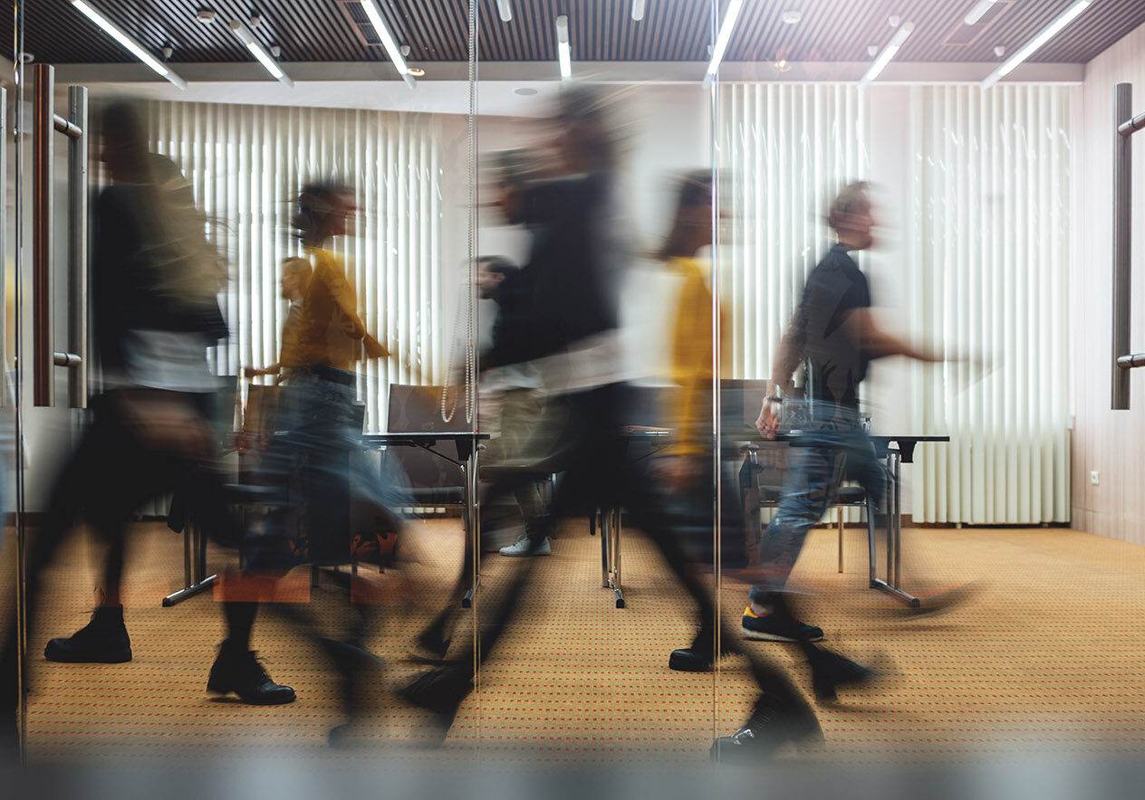 Businesspeople walking at modern office. Group of business employees at coworking center. Motion blur. Concept work process. Wide image