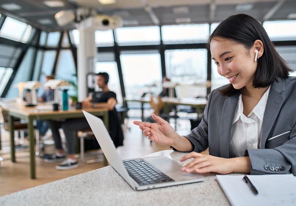 Frau arbeitet hybrid am Laptop